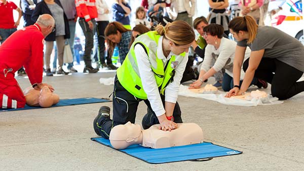 A woman performing safety training in a room full of attendees